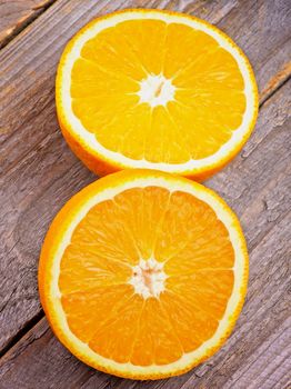 Two Halves of Juicy Ripe Orange isolated on Wooden background. Top View