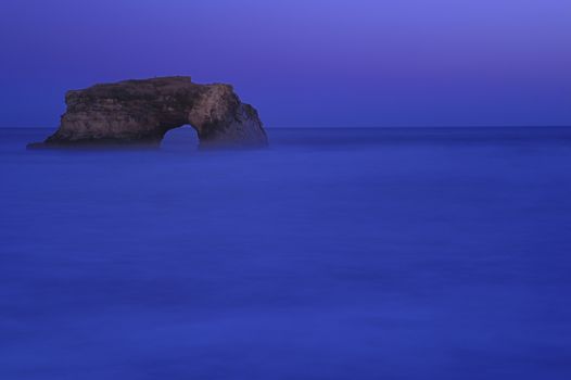 Natural Bridges rock in the Beach of Santa Cruz, California, USA. With ocean wave in the foreground.