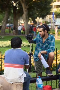 LIMA, PERU - MARCH 3, 2012: Unidentified young man taking a photograph of another person with a Canon EOS 60D camera in Parque Kennedy on March 3, 2012 in Miraflores, Lima, Peru