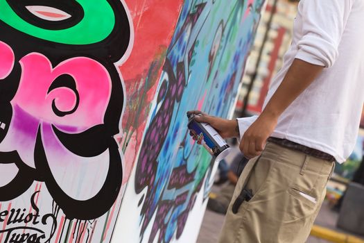 LIMA, PERU - MARCH 3, 2012: Unidentified young man spraying a wall on the Latir Latino, the first Latin-American Street Art Festival on March 3, 2012 in Miraflores, Lima, Peru. Many national and international street artists participated on this Festival, which was organised by the Municipality of Miraflores.