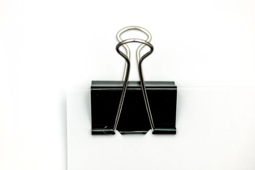 Black clerical clip for paper on white background