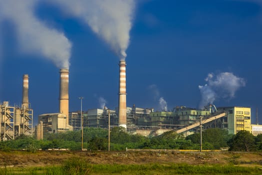 Factory emitting smoke on a bright sunny day