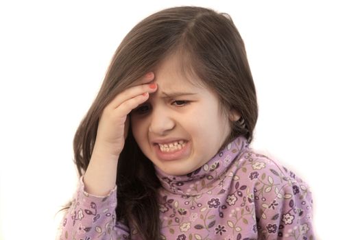 Cute little girl with her hand held to her forehead with painful expression showing headache