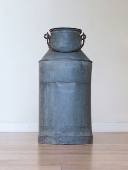 Old metal milk can on white background