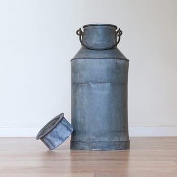 Old metal milk can on white background