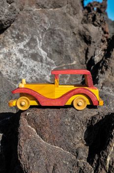 Transportation Concept Wooden Toy Car on the Rocks