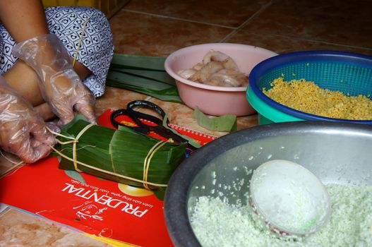 Raw materials  to make Cylindric glutinous rice cake: glutinous rice, green bean, fat pork, banana leaf, glutinous rice filled with green bean paste and fat pork,  two hand wrap up to finish