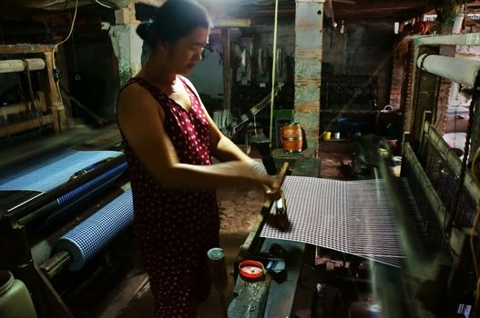 DONG THAP, VIET NAM- NOV 15: People weave striped cloth by power loom at home in Dong Thap, Viet Nam on Nov 15, 2013