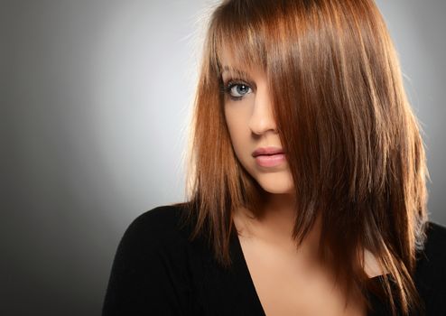 Beautiful young woman over grey background