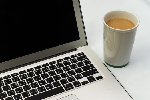 White desk with laptop computer and cup of coffee