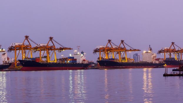 Big crane bridge shipping container cargo in shipyard at twilight. Logistic Import Export background.