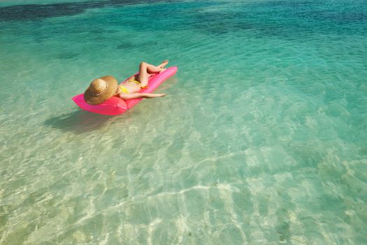 Woman relaxing on inflatable mattress at the beach