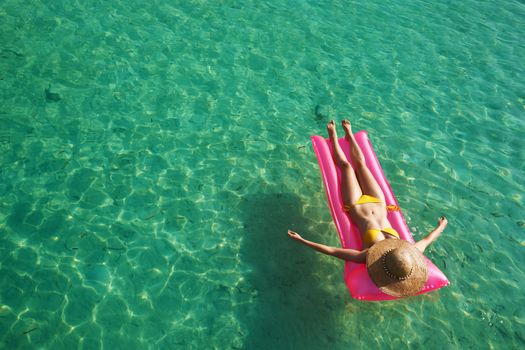 Woman relaxing on inflatable mattress at the beach