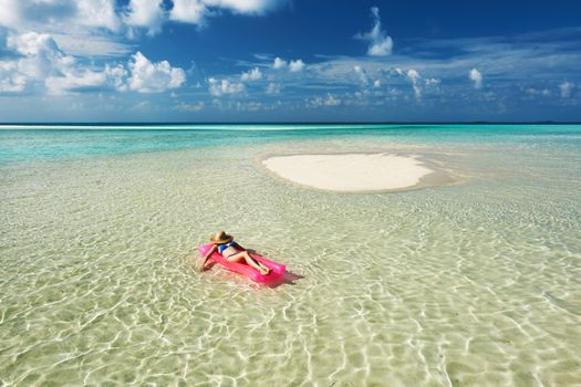 Woman relaxing on inflatable mattress at the beach