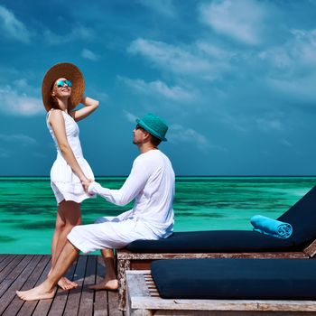 Couple on a tropical beach jetty at Maldives