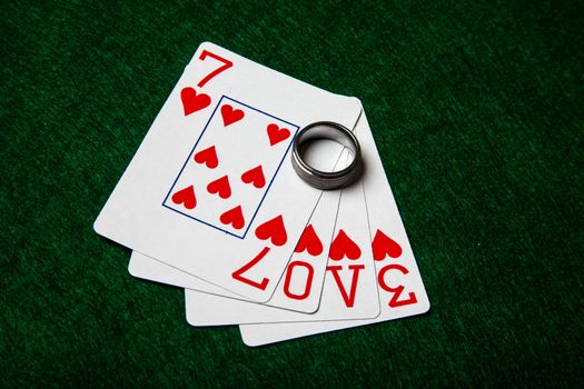 This is a photograph of four poker cards spelling the word love.