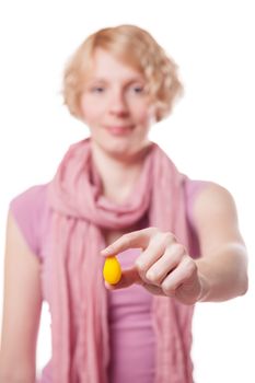 Young Woman Holding a Yellow Easter Egg in front of the Cameras - Isolated on White Background