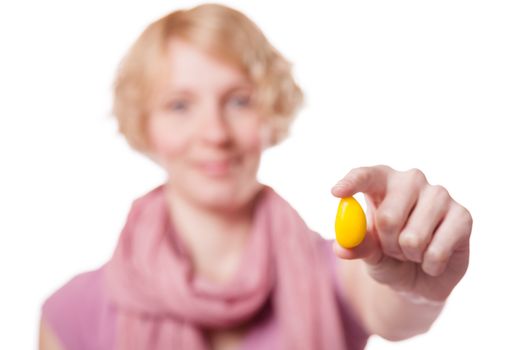 Young Woman Holding a Yellow Easter Egg in front of the Cameras - Isolated on White Background