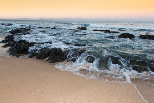 Rough sea and golden sand at the rugged coast in South Africa