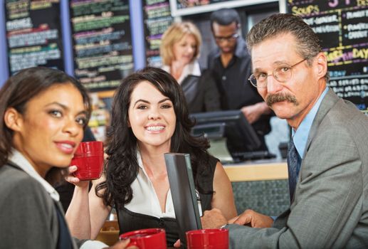 Man with mustache meeting with female coworkers in cafe