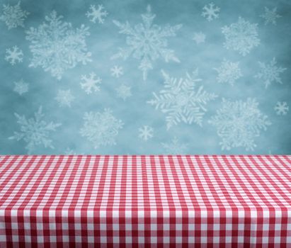 Empty table with red gingham tablecloth over blue background. Great for product display montages