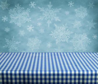 Empty table with blue gingham tablecloth over winter background. Great for product display montages