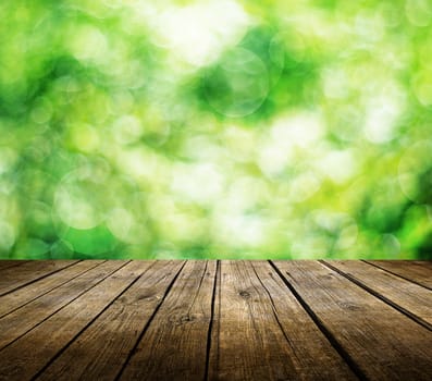 Wooden deck table over beautiful green background