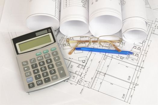 Construction drawings, glasses, calculator and pen. Workplace architect