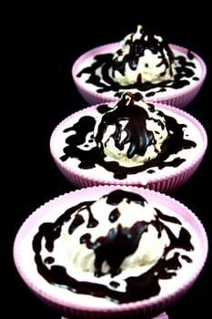 Dessert on a black background in three bowl of chocolate