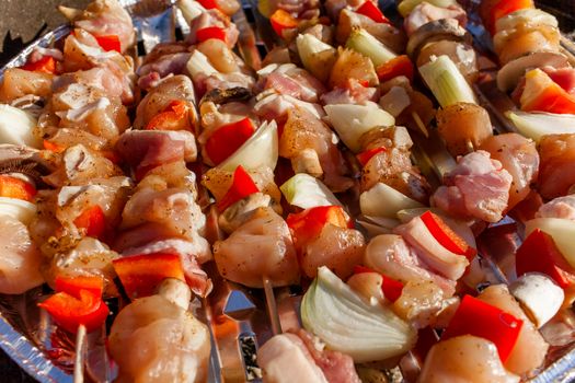 Shashliks, kebab of bacon, pork, sausage, onion and peppers prepared for grill, BBQ.