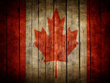 Very old dark brown wooden planks background with Canadian flag painted on it