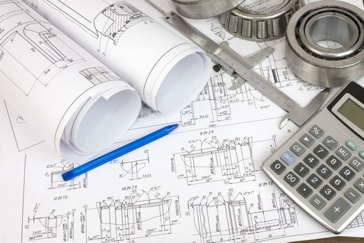 Construction drawings, caliper, bearing, calculator and pen. Desk Engineer