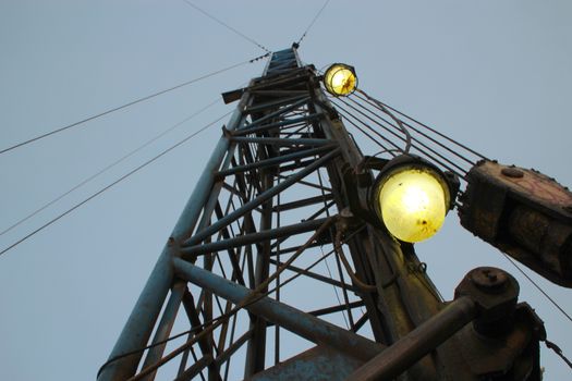 Boom hoist against the evening sky. Boom lit light bulb