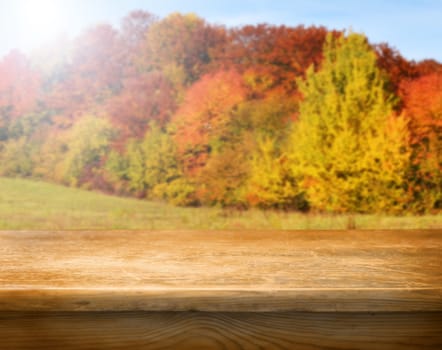 Empty wooden deck table with autumn background. Ready for product display montage.