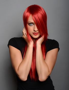 Beautiful red haired woman over gray background