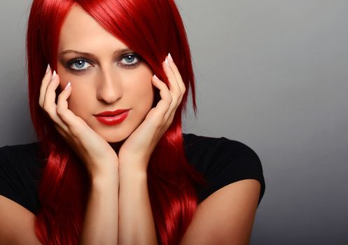 Beautiful red haired woman over gray background