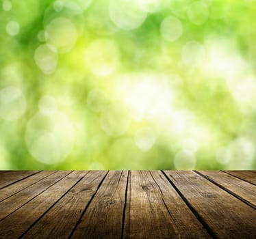 Empty wooden deck table with green spring background. Ready for product display montage.