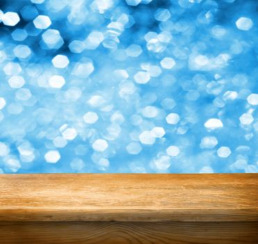 Empty wooden deck table with blue christmas background. Ready for product display montage.