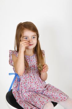 Young smiling girl sitting on a chair. smelling perfume