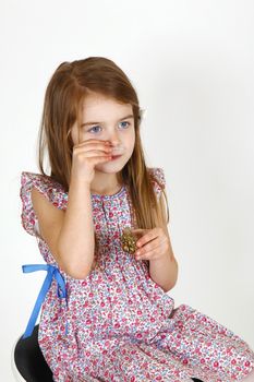Young smiling girl sitting on a chair. smelling perfume