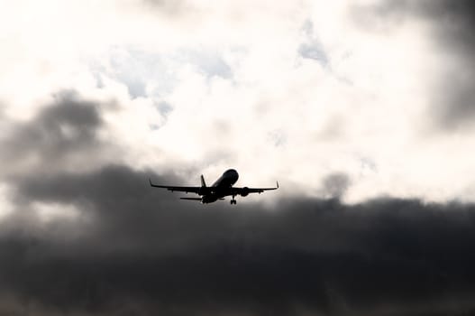 Silhouette of an Airplane Landing over a evening sky