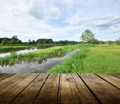 Empty wooden deck table with river in background. Ready for product display montage. 