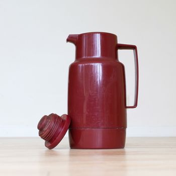 Old coffee tumbler (Thermo bottle) on a wooden table