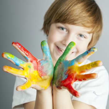 Smiling child showing his colored hands