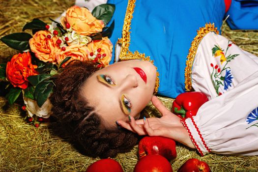 Attractive young girl from Eastern Europe lies on her back on fresh hay