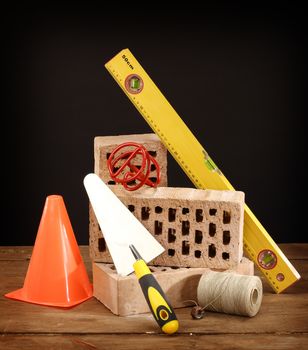 Bricks, trowel and stirrer on work place