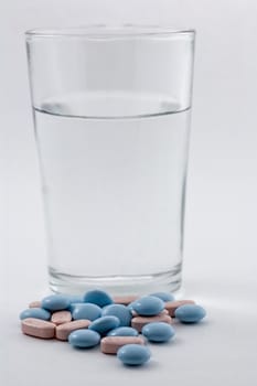 Glass of water and pills isolated on white background