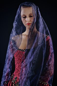 Woman in baroque costume with voile on black background