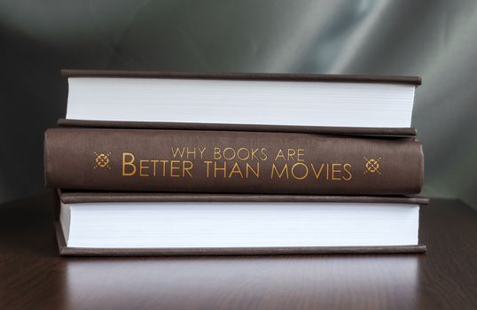 Books on a table and one with "Whz books are better than movies" cover. Book concept.