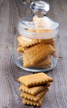 Stack and Glass Jar with Butter Cookies closeup on Rustic Wooden background